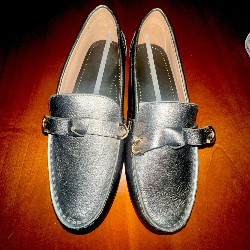 Women’s size 9.5 brand is Cole Haan style. Evelyn bow driver, pewter metallic.